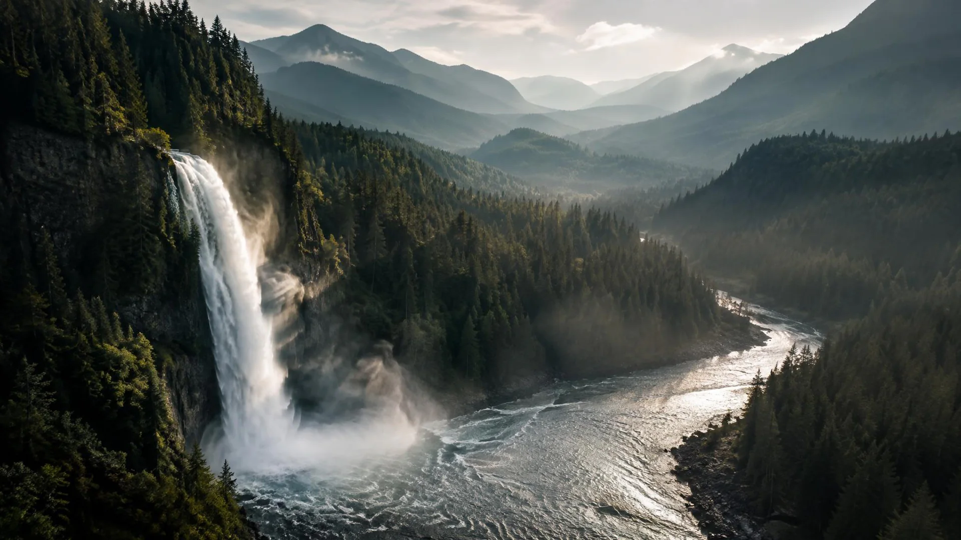 Pacific Northwest waterfall feeding a forested river valley below distant mountain ridges